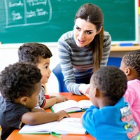 a teacher having a lesson with a group of students age 7-1