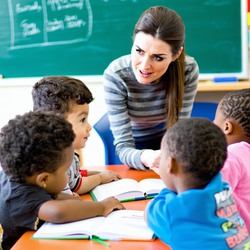 a teacher having a lesson with a group of students age 7-1